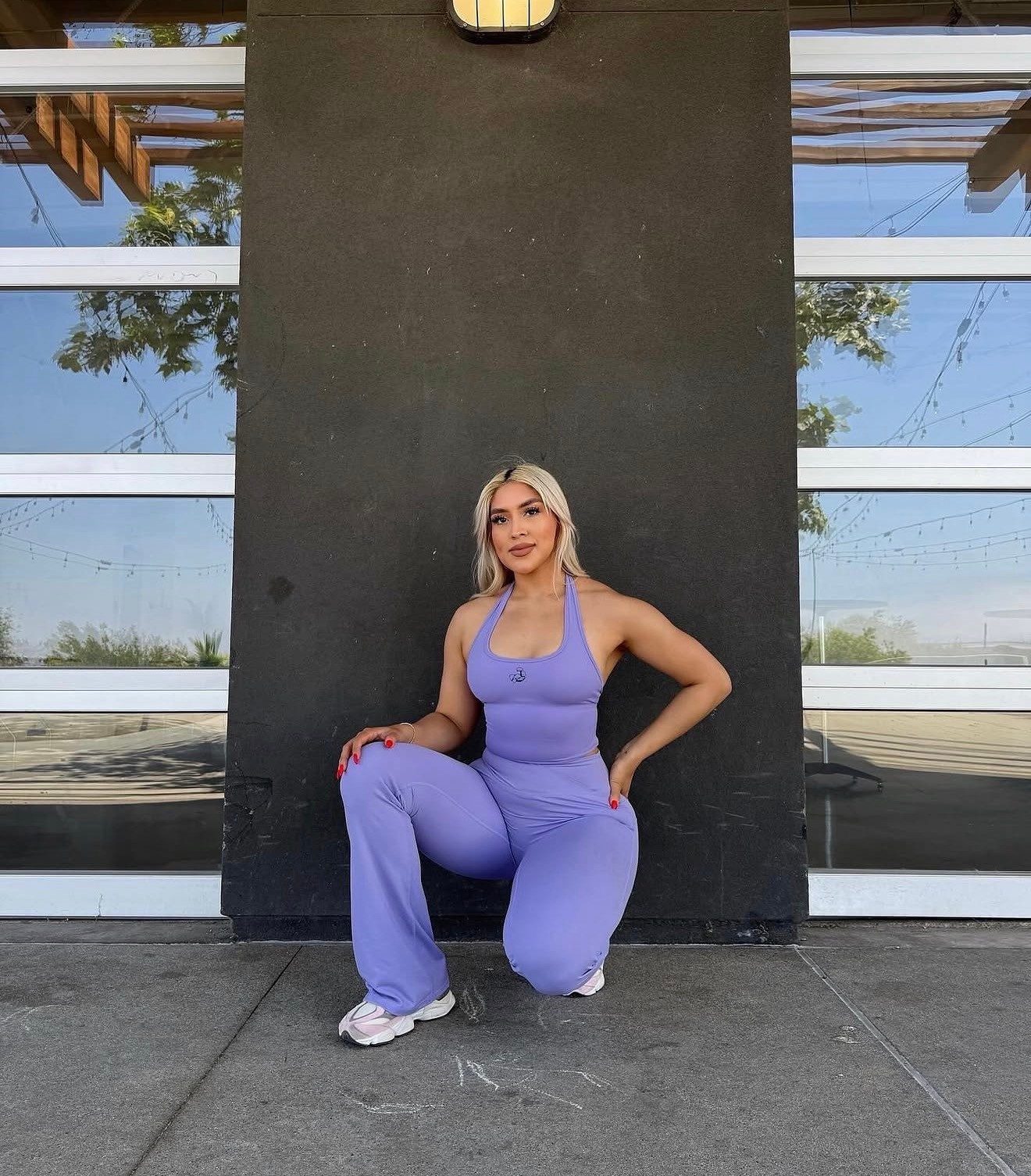 Emily Sanchez in a purple matching set, hand on hip.