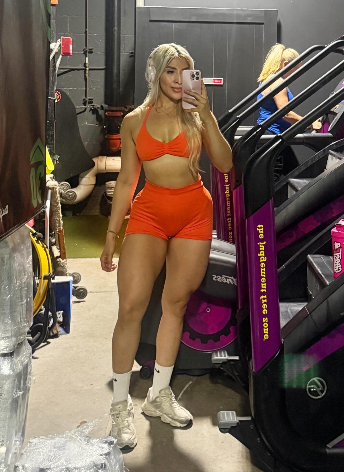 Emily Sanchez taking a gym selfie in an orange set